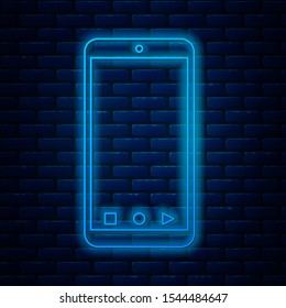 Glowing neon line Mobile smart phone with app delivery tracking icon isolated on brick wall background. Parcel tracking.  Vector Illustration