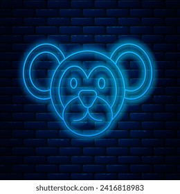 Glowing neon line Monkey icon isolated on brick wall background. Animal symbol.  Vector