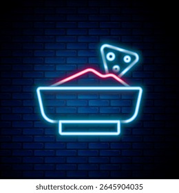 Linha de neon brilhante Nachos no ícone da tigela isolado no fundo da parede de tijolo. Tortilhas ou nachos tortillas. O tradicional menu de fast food mexicano. Conceito de contorno colorido. Vetor