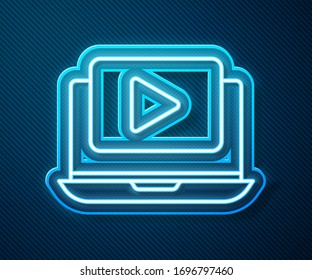 Glowing neon line Online play video icon isolated on blue background. Laptop and film strip with play sign.  Vector Illustration
