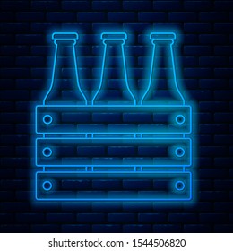 Glowing neon line Pack of beer bottles icon isolated on brick wall background. Wooden box and beer bottles. Case crate beer box sign.  Vector Illustration