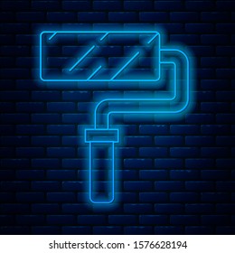 Glowing neon line Paint roller brush icon isolated on brick wall background.  Vector Illustration