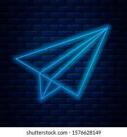 Glowing neon line Paper airplane icon isolated on brick wall background.  Vector Illustration