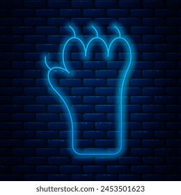 Glowing neon line Paw print icon isolated on brick wall background. Dog or cat paw print. Animal track.  Vector