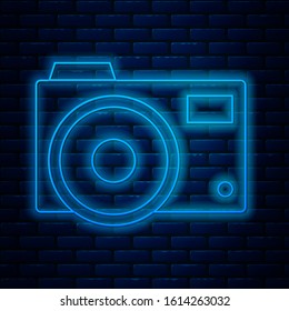 Glowing neon line Photo camera icon isolated on brick wall background. Foto camera icon.  Vector Illustration