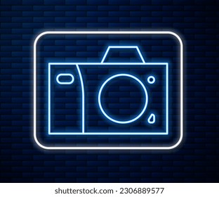 Glowing neon line Photo camera icon isolated on brick wall background. Foto camera icon.  Vector Illustration