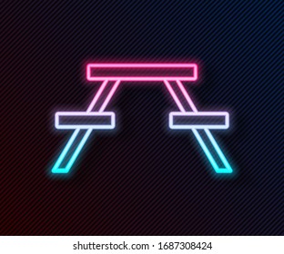 Línea de neón brillante Mesa picnic con bancos a ambos lados del icono de la mesa aislados en fondo negro. Ilustración vectorial