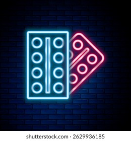 Glowing neon line Pills in blister pack icon isolated on brick wall background. Medical drug package for tablet, vitamin, antibiotic, aspirin. Colorful outline concept. Vector