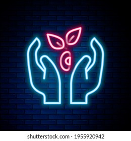Glowing neon line Plant in hand of environmental protection icon isolated on brick wall background. Seed and seedling. Planting sapling. Ecology concept. Colorful outline concept. Vector