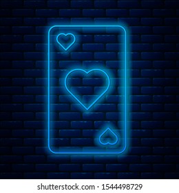 Glowing neon line Playing card with heart symbol icon isolated on brick wall background. Casino gambling.  Vector Illustration