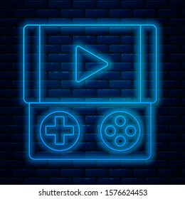 Glowing neon line Portable video game console icon isolated on brick wall background. Gamepad sign. Gaming concept.  Vector Illustration