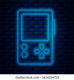 Glowing neon line Portable video game console icon isolated on brick wall background. Gamepad sign. Gaming concept.  Vector Illustration