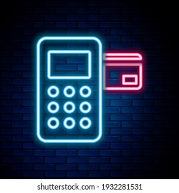 Glowing neon line Pos terminal with inserted credit card icon isolated on brick wall background. Payment terminal transaction. Colorful outline concept. Vector