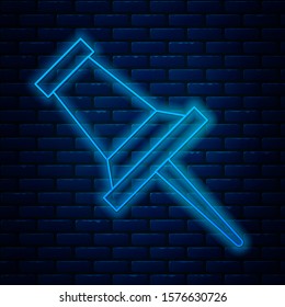 Glowing neon line Push pin icon isolated on brick wall background. Thumbtacks sign.  Vector Illustration