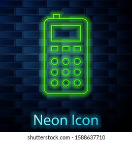 Glowing neon line Remote control icon isolated on brick wall background.  Vector Illustration