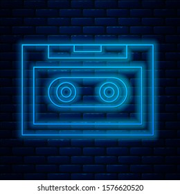 Glowing neon line Retro audio cassette tape icon isolated on brick wall background.  Vector Illustration