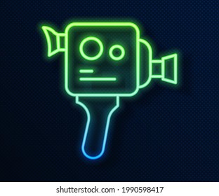 Glowing neon line Retro cinema camera icon isolated on blue background. Video camera. Movie sign. Film projector.  Vector