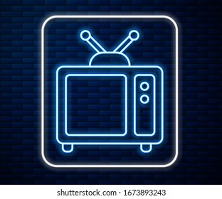 Glowing neon line Retro tv icon isolated on brick wall background. Television sign.  Vector Illustration