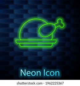Glowing neon line Roasted turkey or chicken icon isolated on brick wall background. Vector