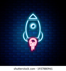 Glowing neon line Rocket ship with fire icon isolated on brick wall background. Space travel. Colorful outline concept. Vector