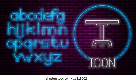 Glowing neon line Round table icon isolated on brick wall background. Neon light alphabet. Vector Illustration