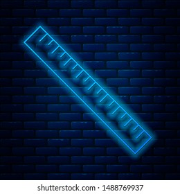 Glowing neon line Ruler icon isolated on brick wall background. Straightedge symbol.  Vector Illustration