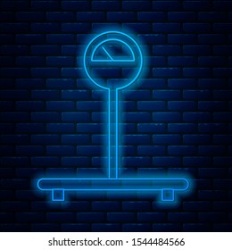 Glowing neon line Scale icon isolated on brick wall background. Logistic and delivery. Weight of delivery package on a scale.  Vector Illustration