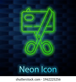 Glowing neon line Scissors cutting a credit card icon isolated on brick wall background. Online payment. Cash withdrawal. Financial operations. Shopping sign. Vector