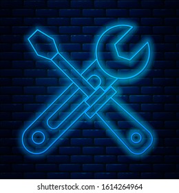 Glowing neon line Screwdriver and wrench tools icon isolated on brick wall background. Service tool symbol.  Vector Illustration