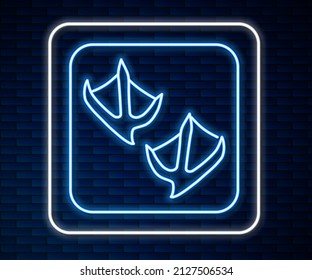 Línea de neón brillante Icono de la huella de la pata de gaviota aislado en el fondo de la pared de ladrillo.  Vector