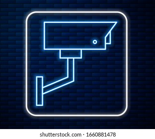 Glowing neon line Security camera icon isolated on brick wall background.  Vector Illustration