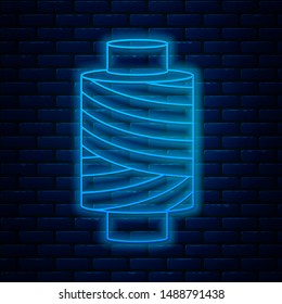 Glowing neon line Sewing thread on spool icon isolated on brick wall background. Yarn spool. Thread bobbin.  Vector Illustration