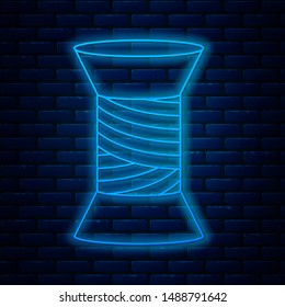 Glowing neon line Sewing thread on spool icon isolated on brick wall background. Yarn spool. Thread bobbin.  Vector Illustration
