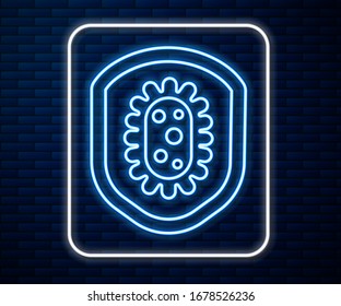 Glowing neon line Shield protecting from virus, germs and bacteria icon isolated on brick wall background. Immune system concept. Corona virus 2019-nCoV.  Vector Illustration
