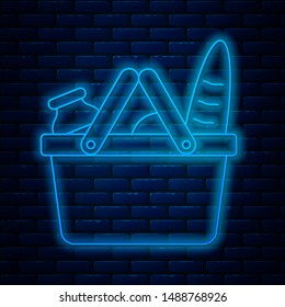 Glowing neon line Shopping basket and food icon isolated on brick wall background. Food store, supermarket.  Vector Illustration