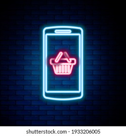 Glowing neon line Shopping basket on screen smartphone icon isolated on brick wall background. Concept e-commerce, e-business, online business marketing. Colorful outline concept. Vector