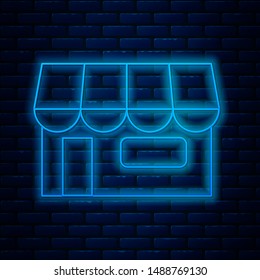 Glowing neon line Shopping building or market store icon isolated on brick wall background. Shop construction.  Vector Illustration