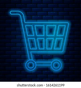 Glowing neon line Shopping cart icon isolated on brick wall background. Online buying concept. Delivery service sign. Supermarket basket symbol.  Vector Illustration
