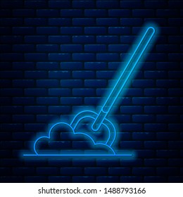 Glowing neon line Shovel in the ground icon isolated on brick wall background. Gardening tool. Tool for horticulture, agriculture, farming.  Vector Illustration
