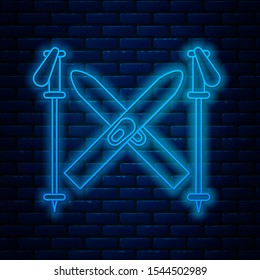 Glowing neon line Ski and sticks icon isolated on brick wall background. Extreme sport. Skiing equipment. Winter sports icon.  Vector Illustration
