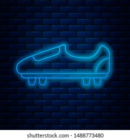 Glowing neon line Soccer or football shoes with spikes icon isolated on brick wall background. American football boot.  Vector Illustration
