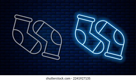 Glowing neon line Socks icon isolated on brick wall background.  Vector