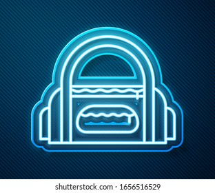 Glowing neon line Sport bag icon isolated on blue background.  Vector Illustration