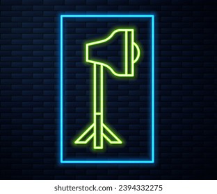 Glowing neon line Studio light bulb in softbox icon isolated on brick wall background. Shadow reflection design.  Vector