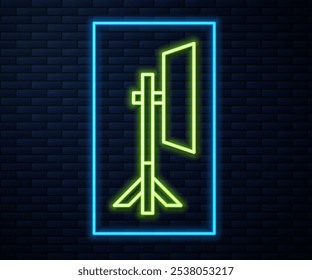 Glowing neon line Studio light bulb in softbox icon isolated on brick wall background. Shadow reflection design.  Vector