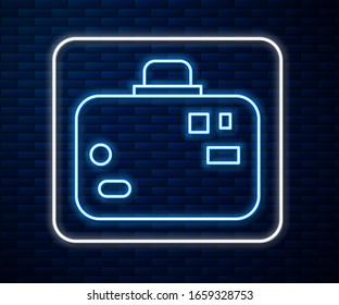 Glowing neon line Suitcase for travel icon isolated on brick wall background. Traveling baggage sign. Travel luggage icon.  Vector Illustration