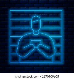 Glowing neon line Suspect criminal icon isolated on brick wall background. The criminal in prison, suspected near the board.  Vector Illustration