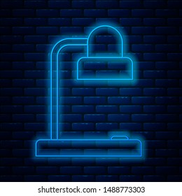 Glowing neon line Table lamp icon isolated on brick wall background. Table office lamp.  Vector Illustration