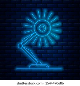 Glowing neon line Table lamp icon isolated on brick wall background. Table office lamp.  Vector Illustration