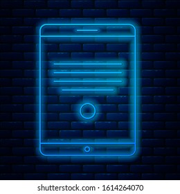 Glowing neon line Tablet icon isolated on brick wall background.  Vector Illustration